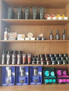Shelf of haircare and grooming products for sale at Jugga's Barbers, including American Crew, Muk, King Brown and Proraso